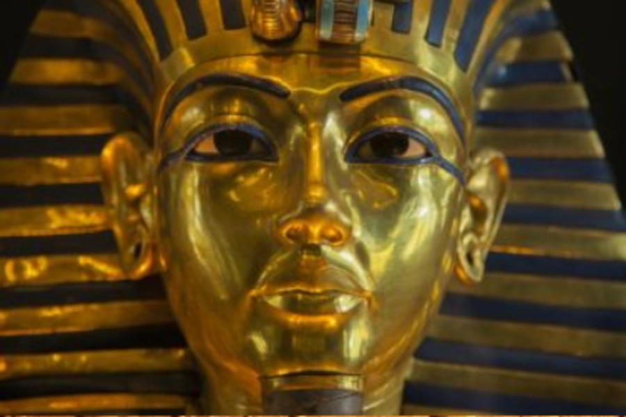 Golden ancient Egyptian pharaoh mask with striped headdress, featuring detailed facial features and black accents on eyes.